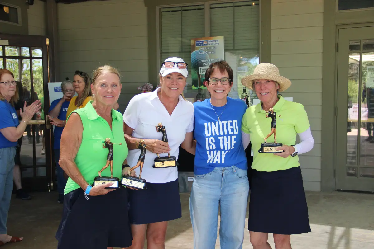Women's division champions display trophies at the Live United Golf Classic awards ceremony